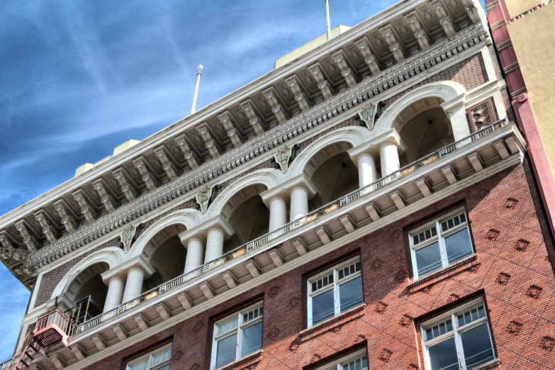 looking up at a large brick building with arches and pillars