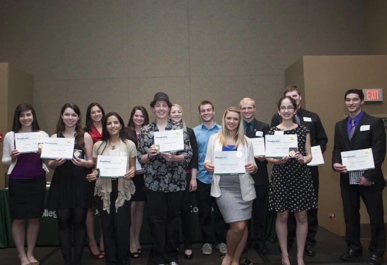 a group of people holding up papers in front of a wall