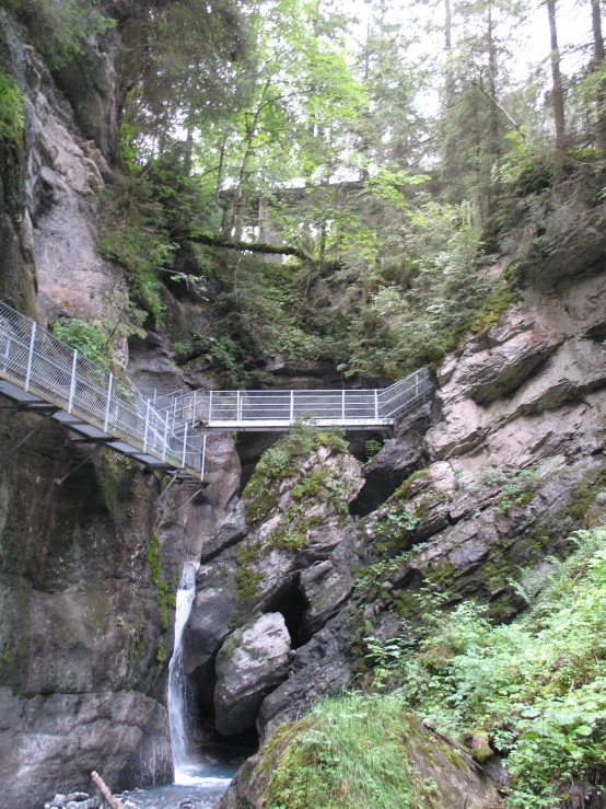 a hike trail going over a bridge on a waterfall