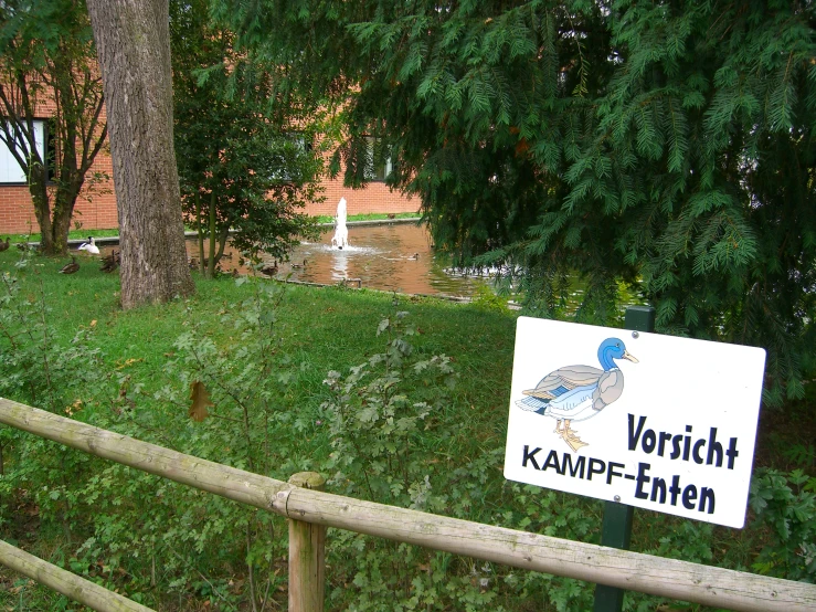 an arrow sign on a fence and a water source