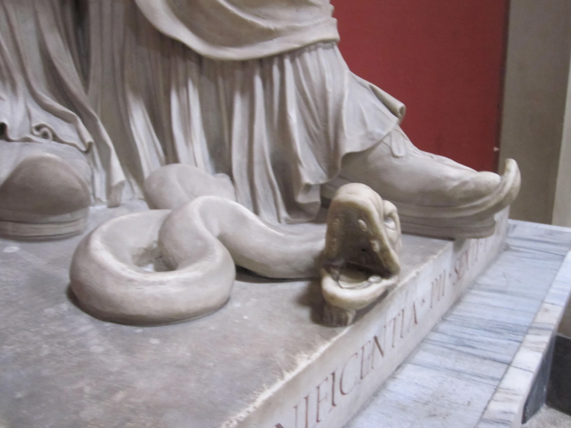 statue with white shoes inside a red room