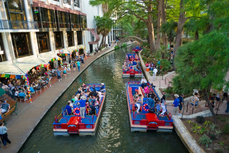 several canal boats are floating on the river