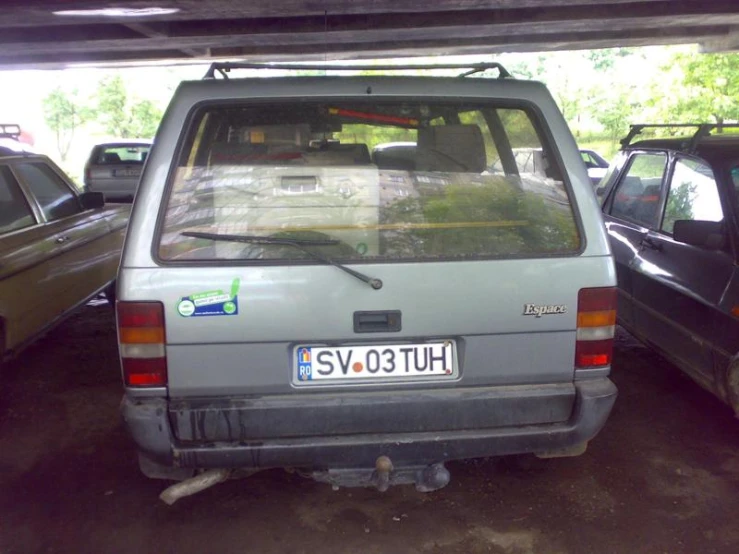 a silver minivan parked in the parking lot with other cars