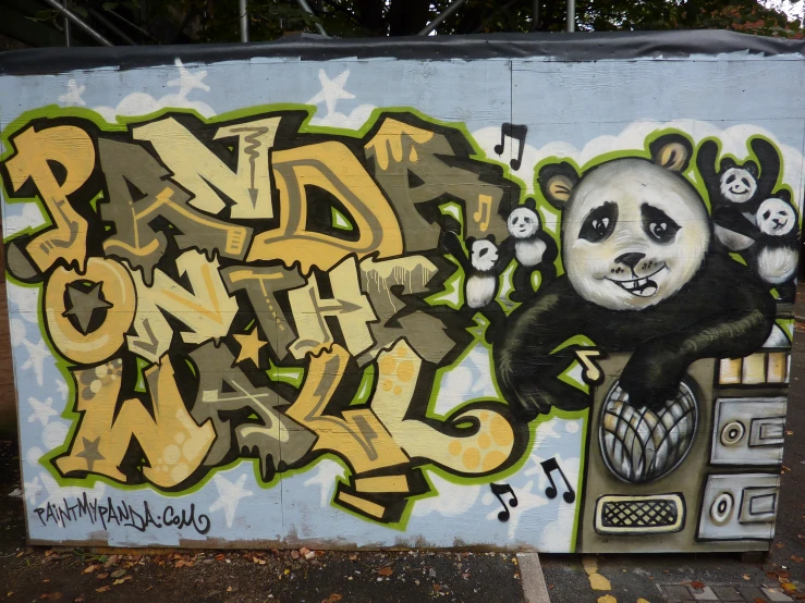 graffiti on a wall depicting a panda holding a microphone