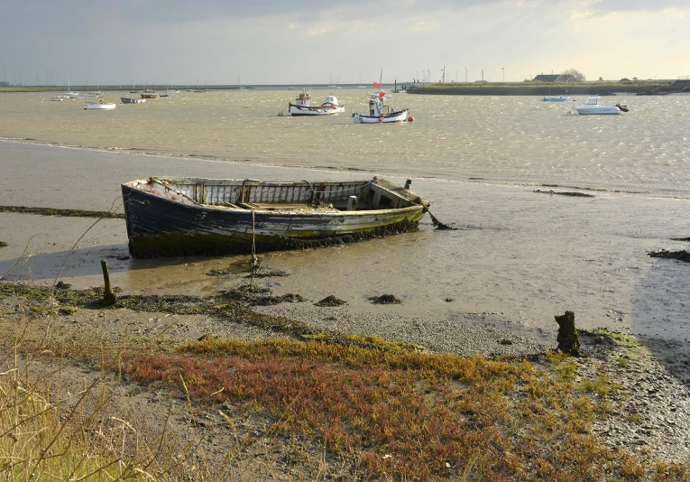 two small boats are anchored on a beach