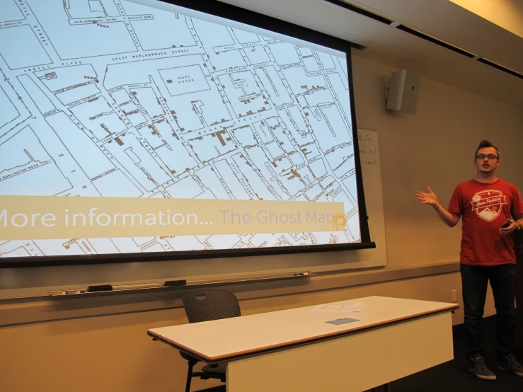 man standing in front of projection screen presenting a map