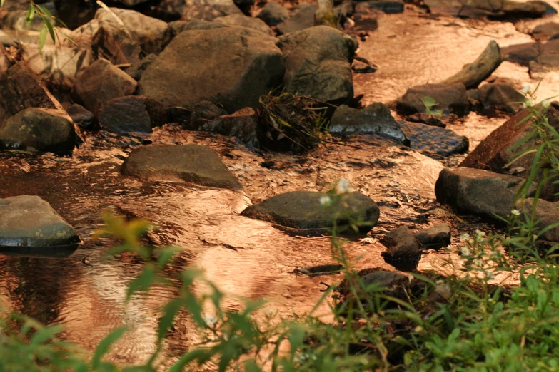 a rocky river that is next to the water