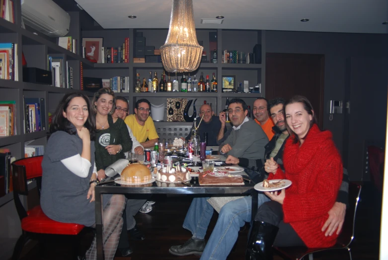 several people sitting at a table with food and drinks