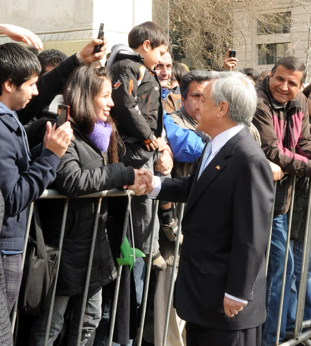 a crowd of people standing near each other behind barricades