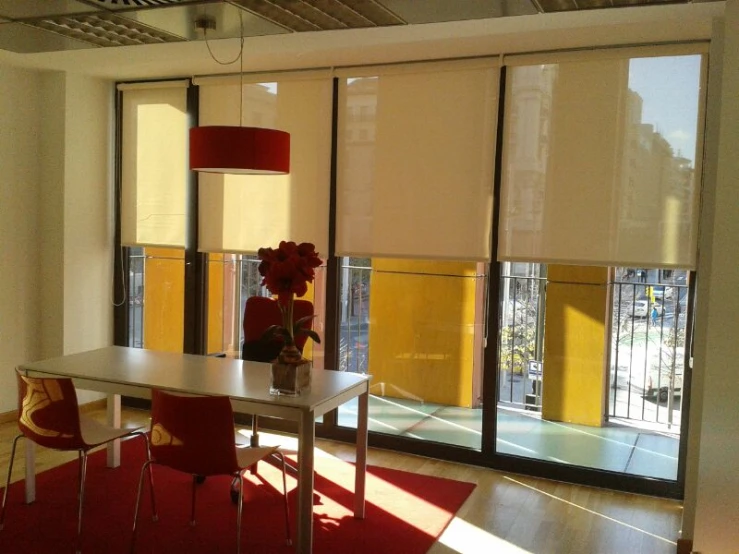 an office room with large windows and a table with a chair