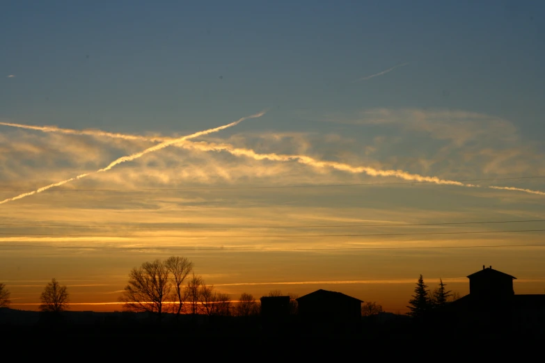 a cross in the sky above some houses