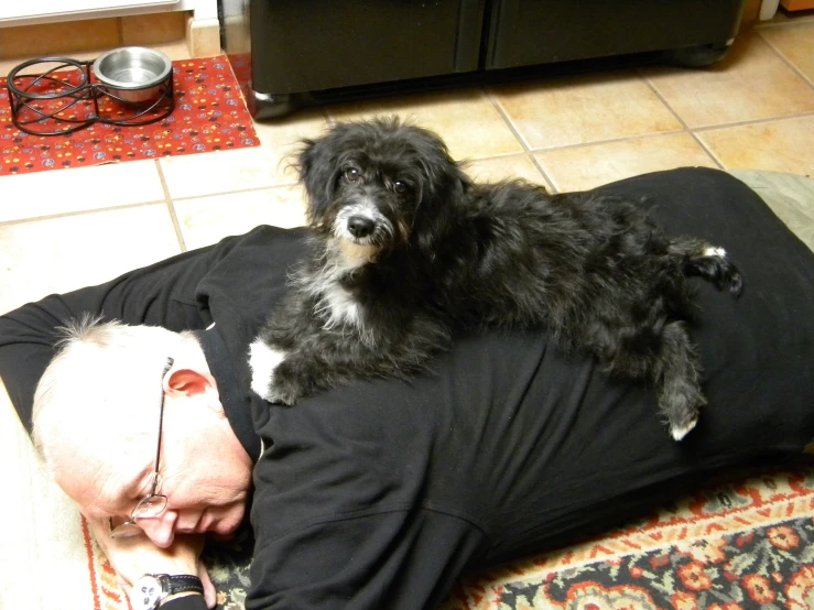 a man lays on the ground with a dog