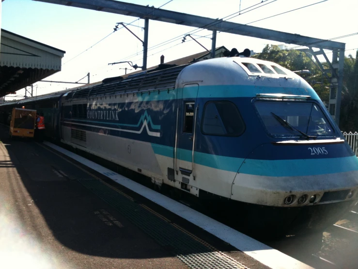 a blue and white train pulling into the station