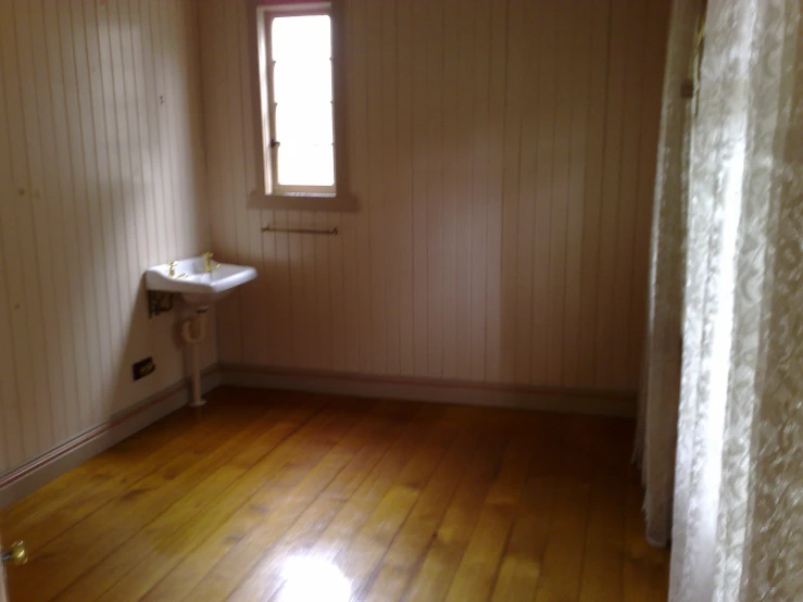 a white sink in a bathroom sitting on a hardwood floor