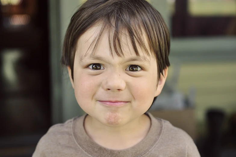 a young child with dark hair smiles while smiling at the camera