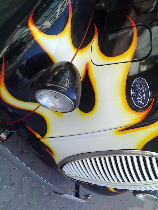 a large shiny black car with flame pattern