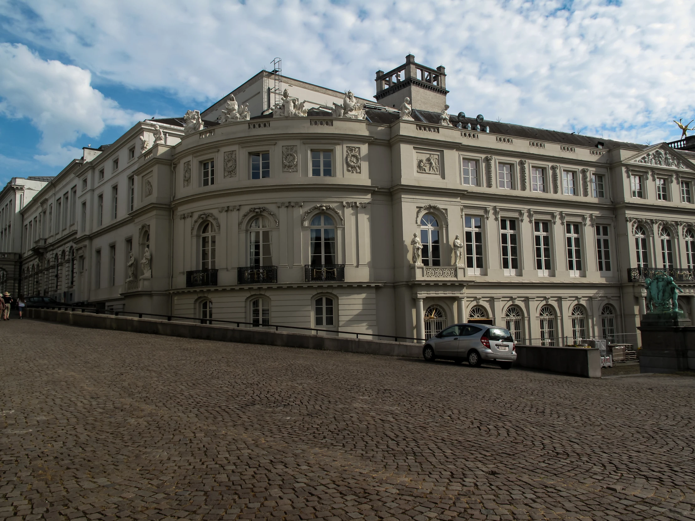 a building with several balconies sits in the middle of a cobblestone street