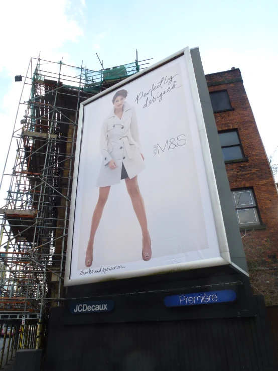 a billboard advertises michael korshen's clothing line in front of a building under construction