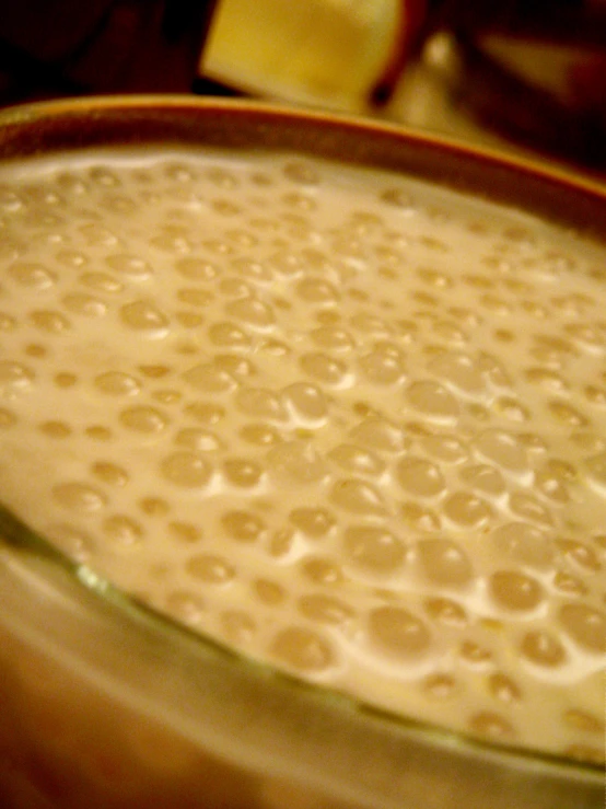 a closeup of a bowl of milk with a spoon