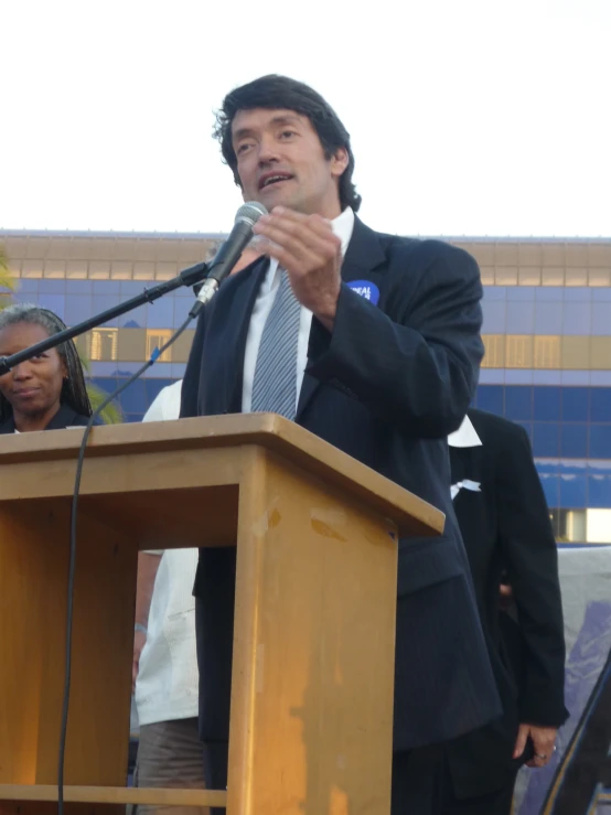 the man stands in front of a podium and speaking into the microphone