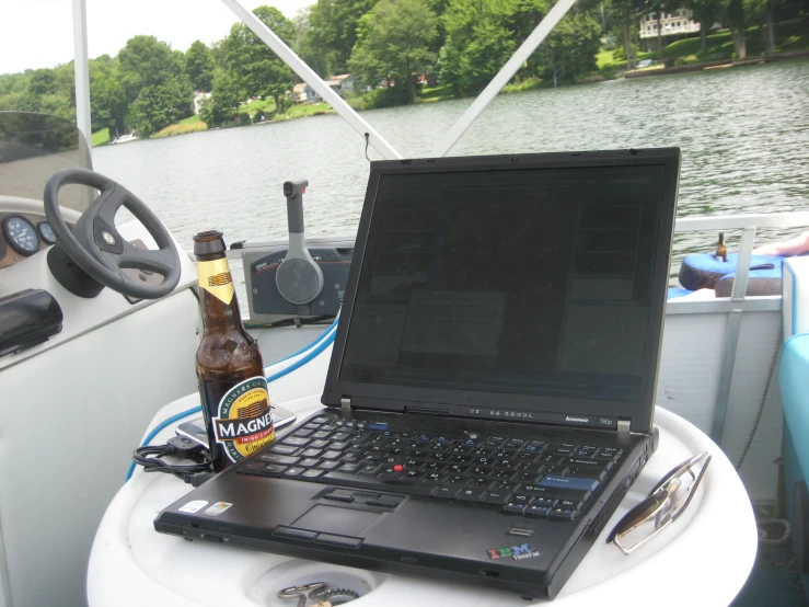 a laptop and beer are on a boat