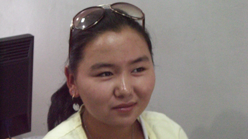 a woman with glasses on her head posing for the camera