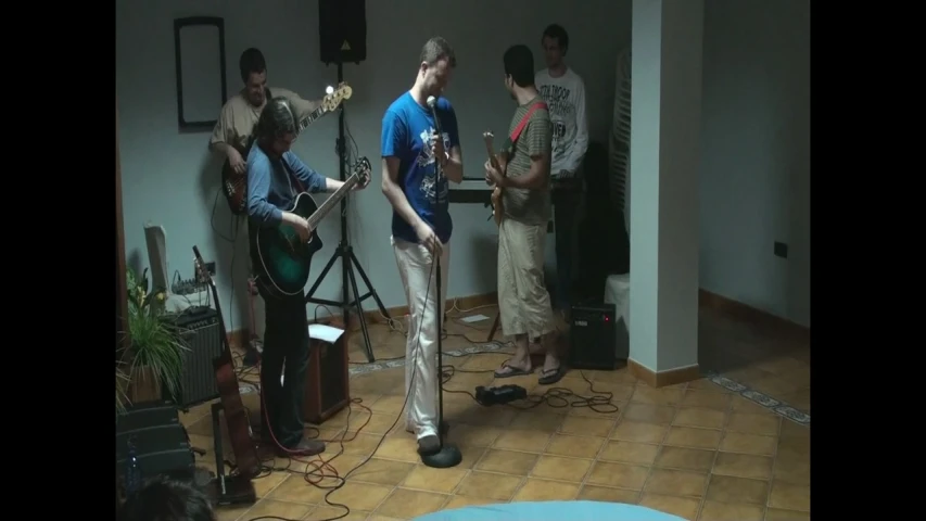 a group of men are playing guitar in the same room