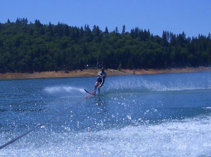 a man on water skis rides the water by himself