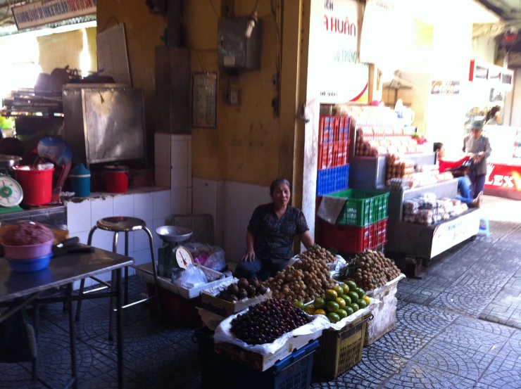 a man is sitting in the shade near fruit