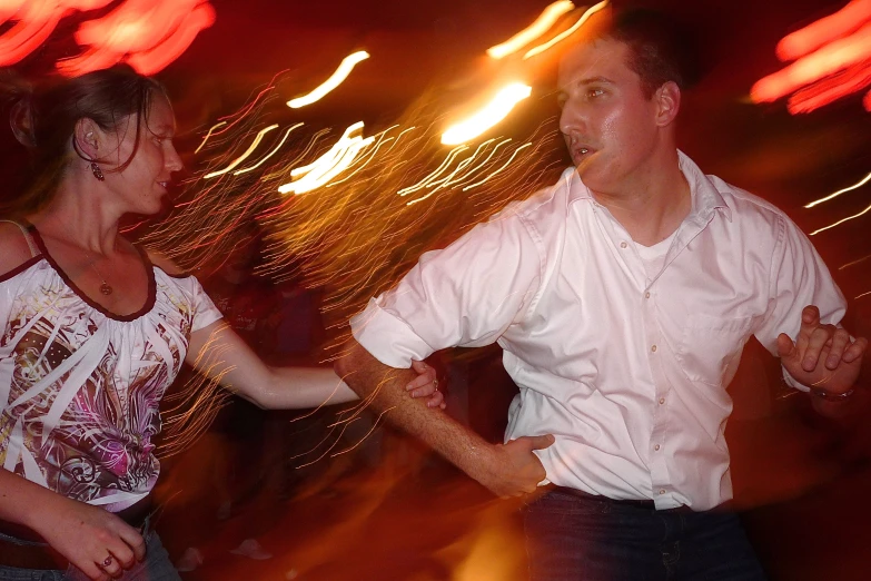 two people dancing in front of some neon lights