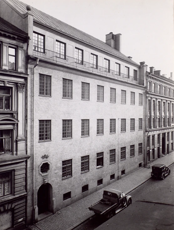 a vintage po of old buildings with car in the foreground