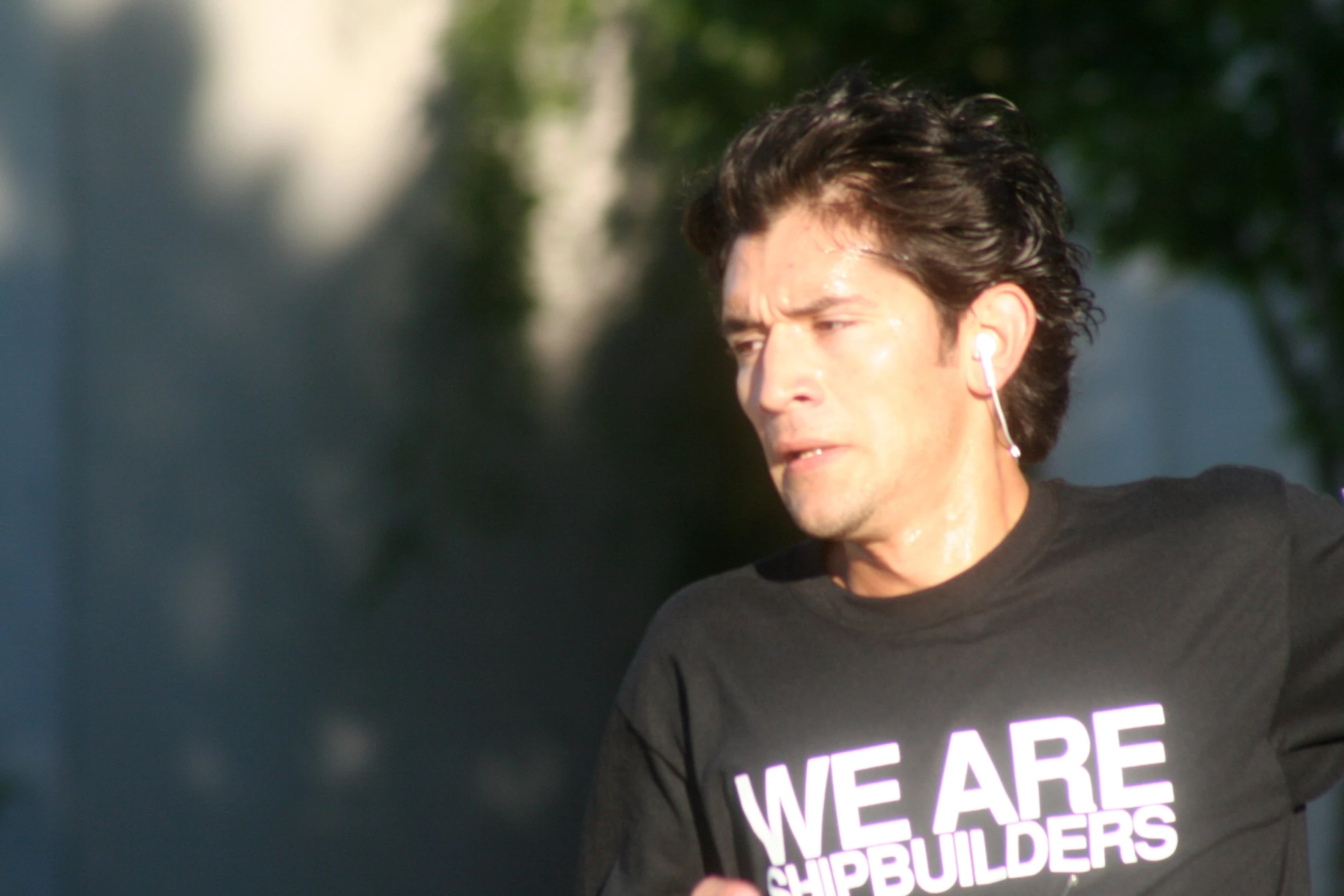 a man with ear buds on his ears and a t shirt that reads we are boulderrs