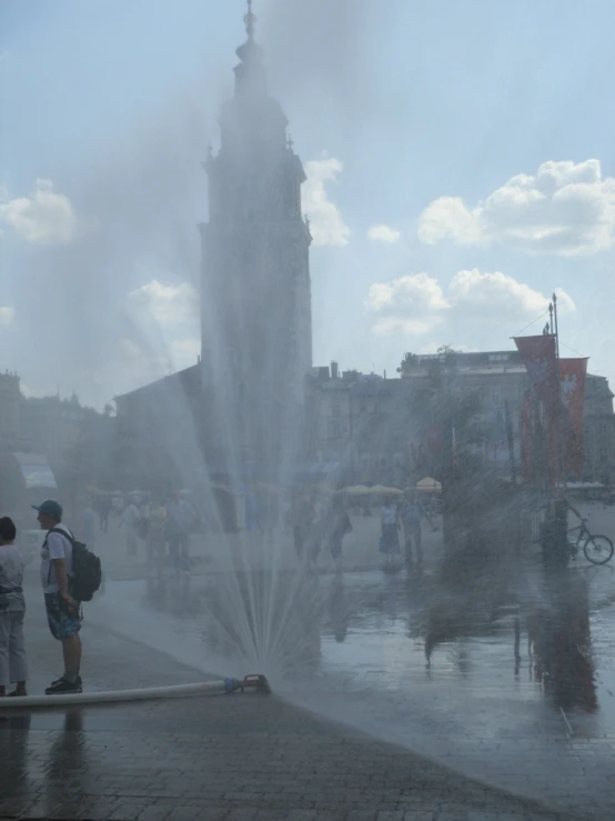 water shoots up in the air while people stand near