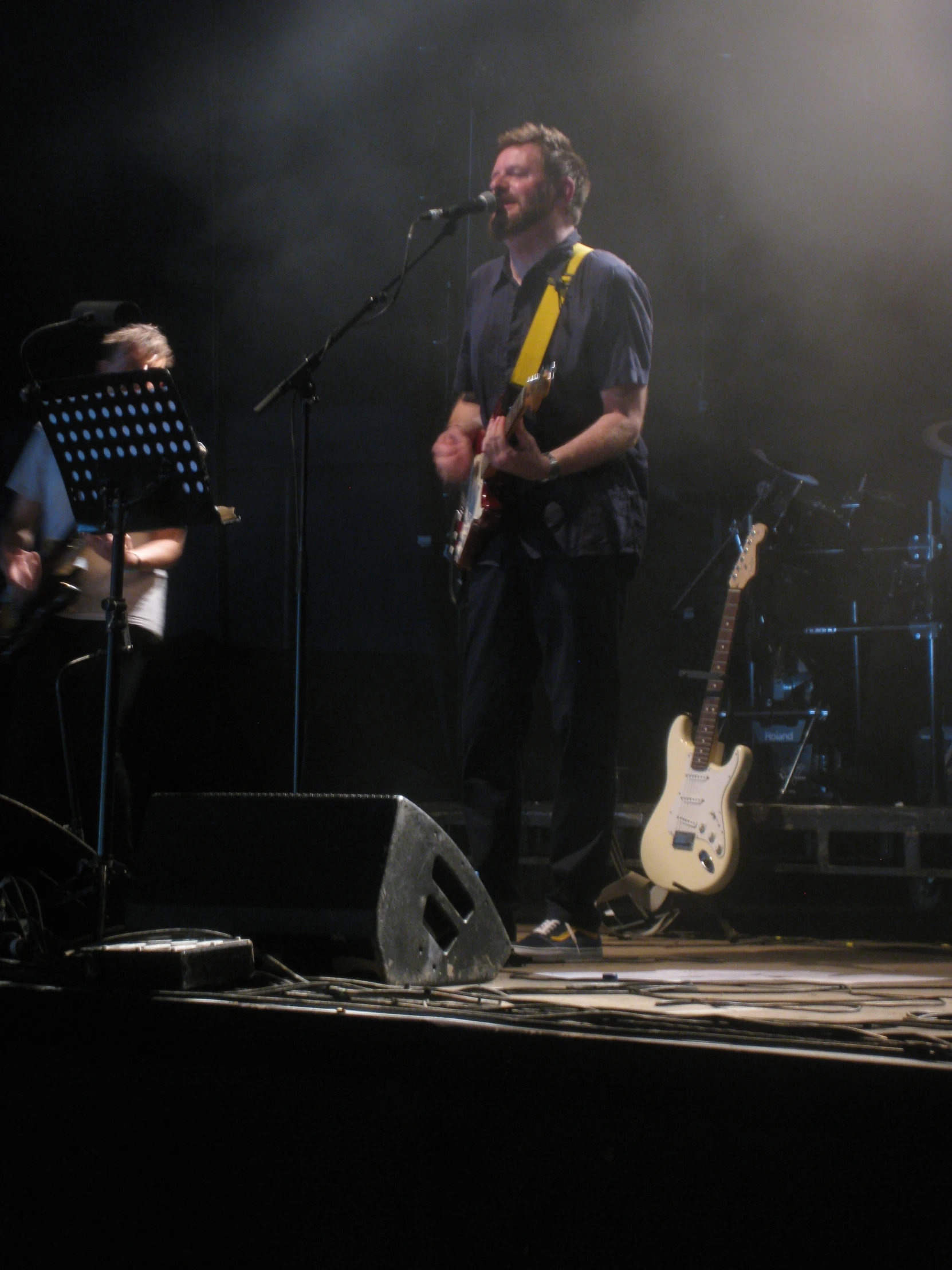 two men are standing on stage with guitars