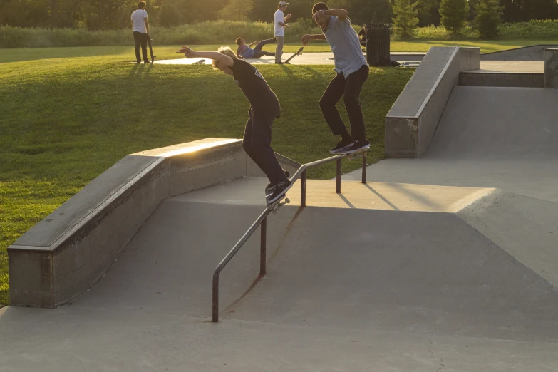 a young man riding a rail on top of a skateboard