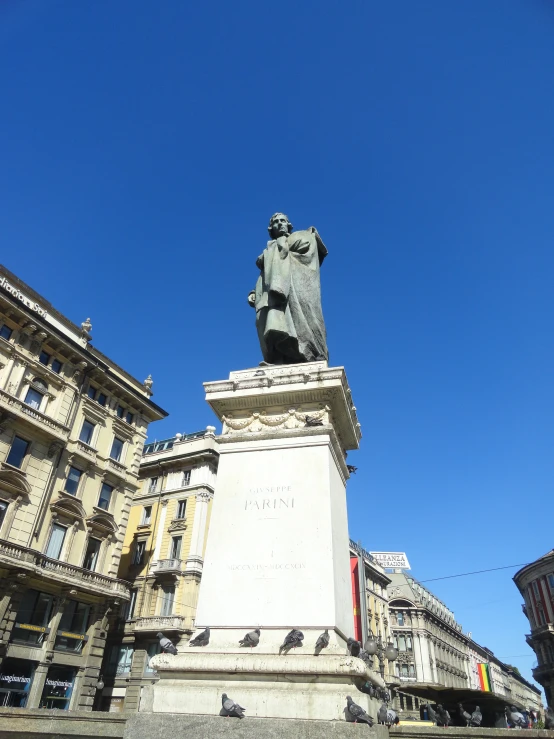 a statue of a person near a building and a clock tower