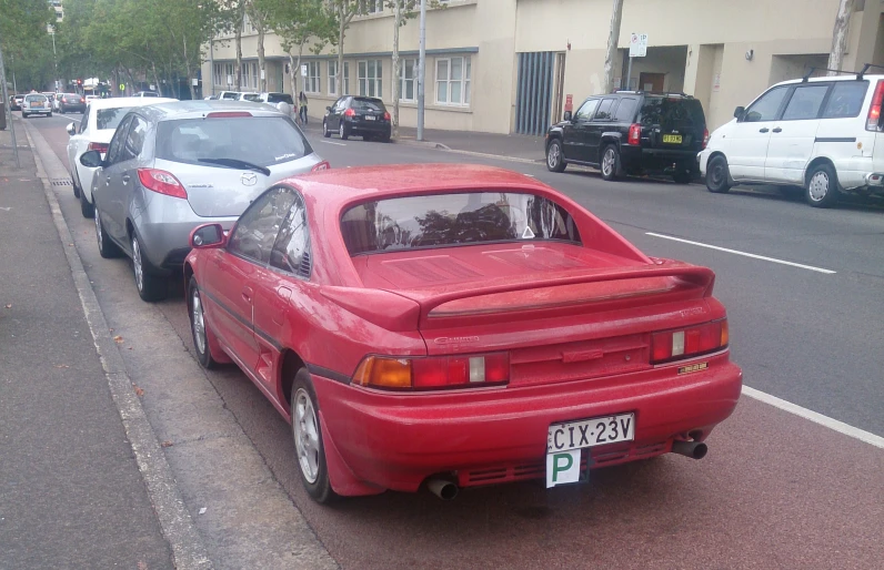 two cars on a road lined with parked cars