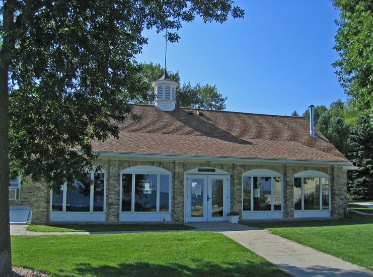 the building has double glass doors and is near trees