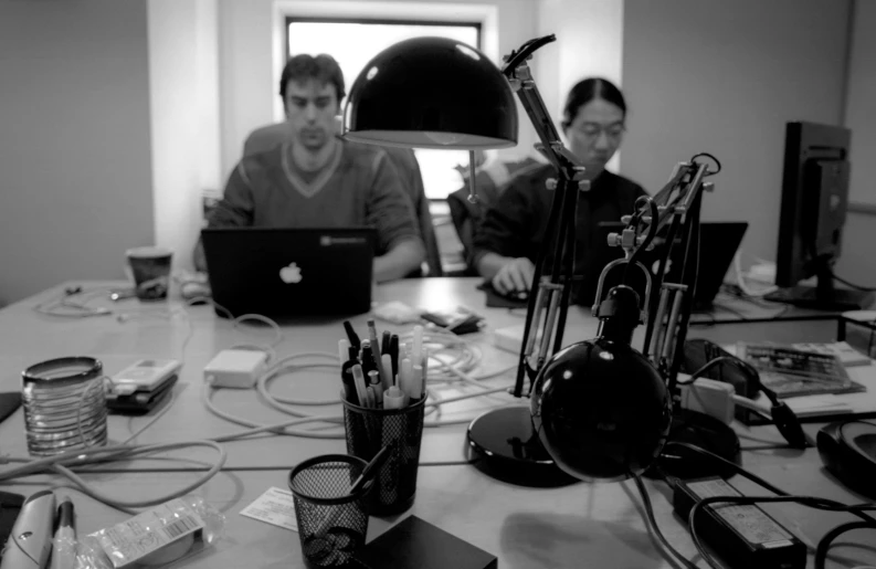 a group of people sitting at a table using laptops