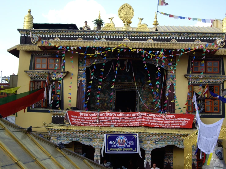 a yellow building with many colorful flags on it