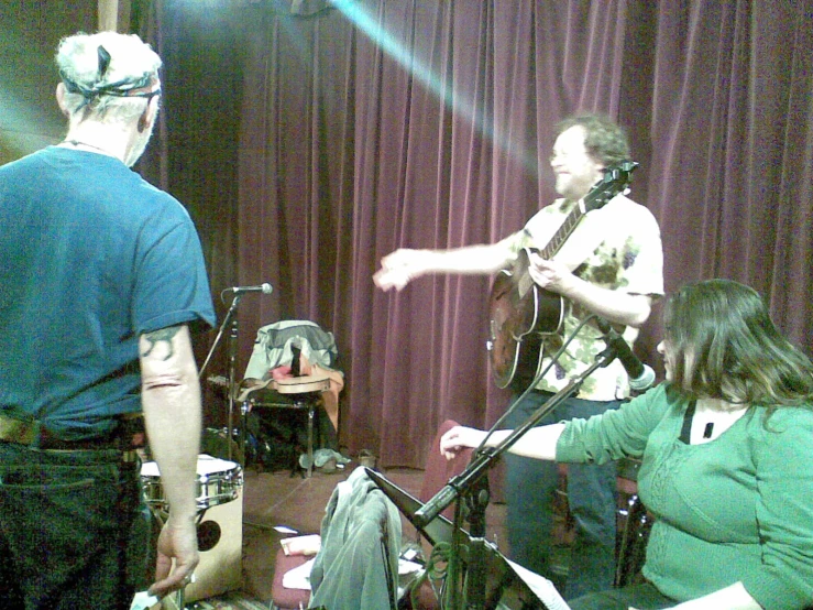 two men standing next to each other playing musical instruments