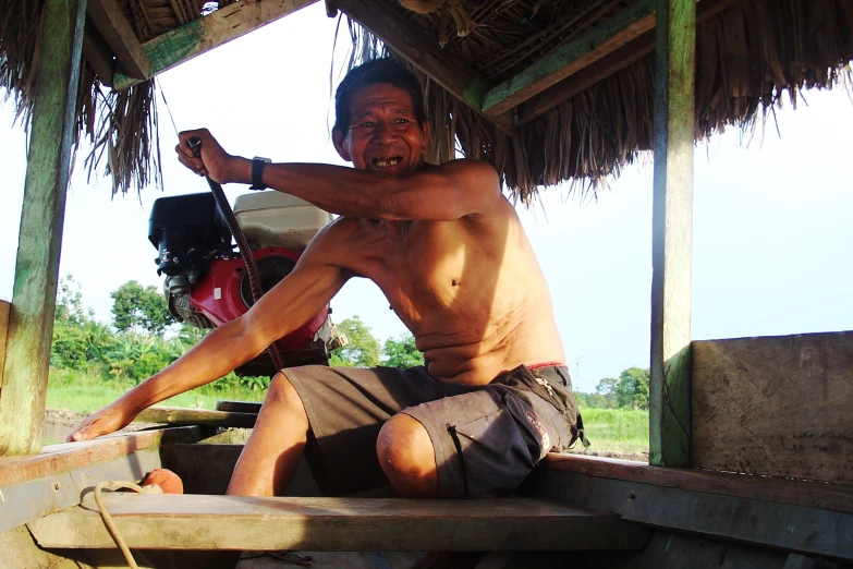 a man sitting on top of a wooden bench next to a cow