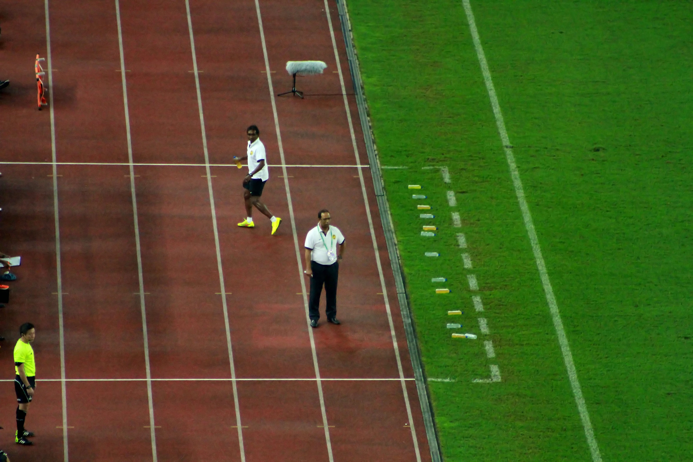 athletes stand on the field waiting for their turn