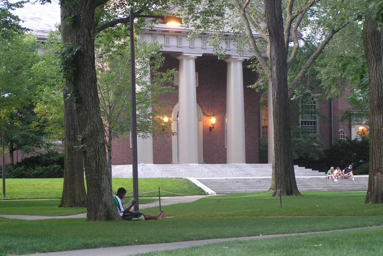 two students sitting on the ground in front of an ornate building