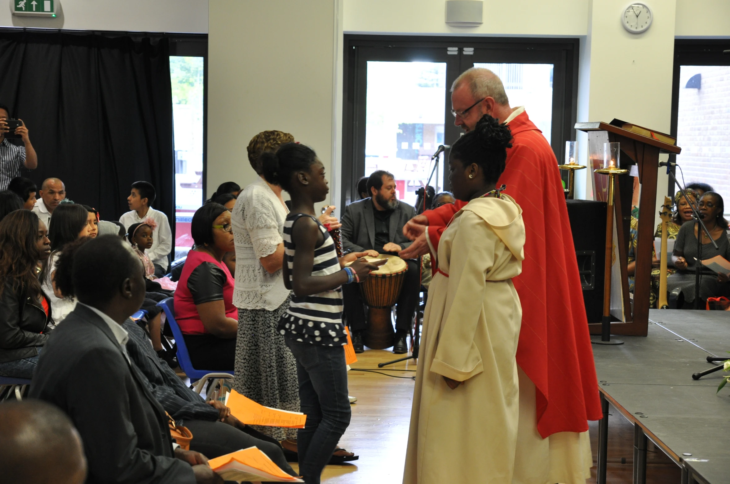 a priest is shown holding a small child