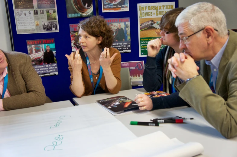 group of people sitting at table clapping hands