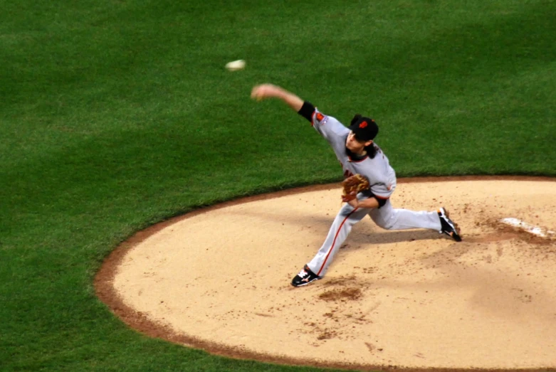 a pitcher on the mound throwing the baseball