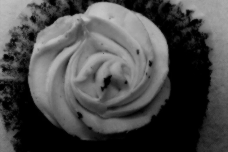 a frosted cupcake is displayed in a bowl