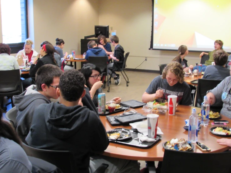 a bunch of people sitting around tables in a room