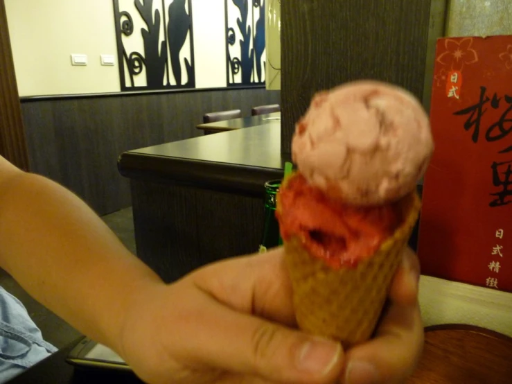 a person holding a ice cream cone filled with pink gel